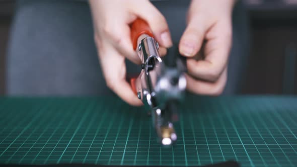 Worker Makes Holes in Black Leather Cloth with Punch Pliers alt