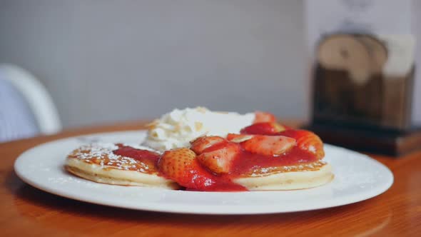 Close up pancake with strawberries, whip cream at cafe.