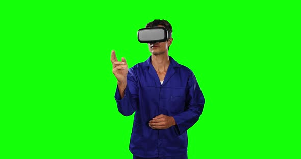 Front view of mechanic using virtual reality and touching screen with green screen alt