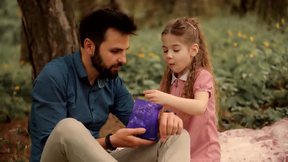 Father's Day. Daughter Kid With Father Eating Sweets. Daughter With Cheerful Father Eat Candy. alt