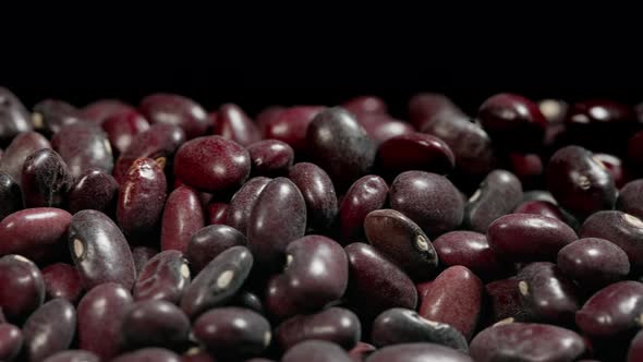 Close-up of red bean seeds on a black background. slider motion, red beans abstract.