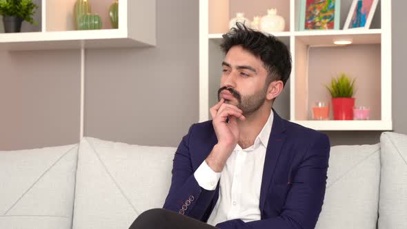 Thoughtful man sitting on the sofa. Business man. alt