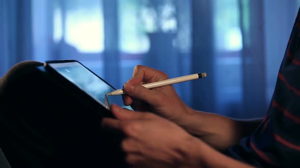Artist Drawing a Picture Using His Tablet With Stylus at Home.