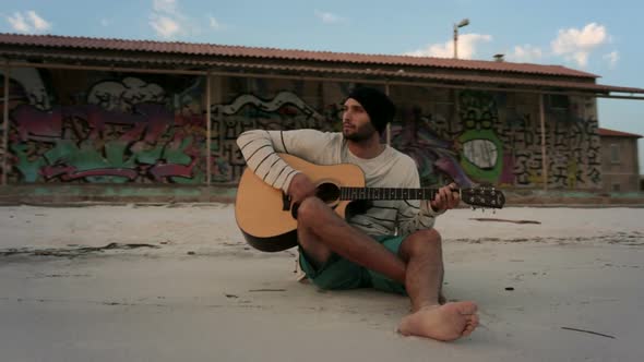 Walk Around Young Beautiful Man Playing Guitar at Ocean Beach Seaside at Sunrise or Sunset in Summer