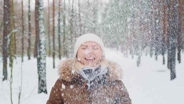 Winter Fun Outside Woman Throwing Snow in the Air and Smiling