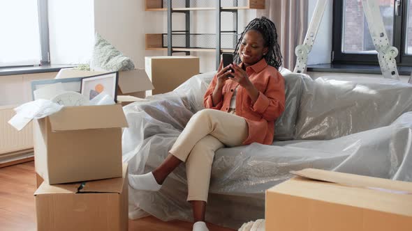 Happy Woman with Smartphone Moving to New Home