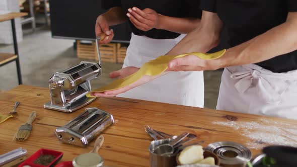 Diverse group of chefs preparing dishes and smiling in a kitchen alt