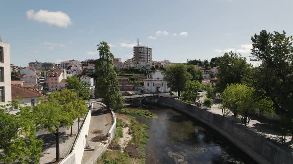 Flying forward over Lis river on Leiria town centre, Sunny day - Portugal