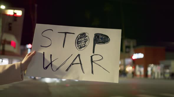 Slow Motion Outdoor Closeup of Women Activists Hand with STOP the WAR Poster alt