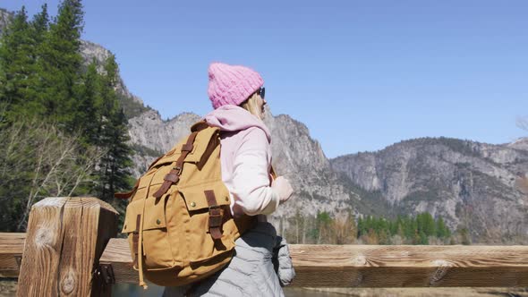 Woman Traveler with Tourist Backpack on Wooden Bridge in Green Yosemite Forest alt