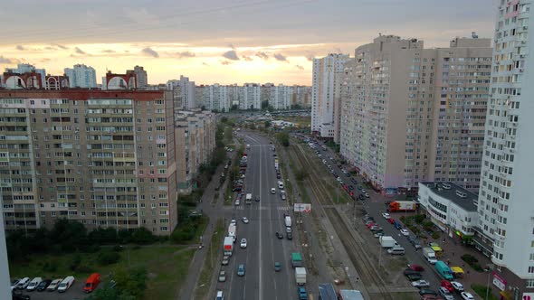 Aerial view overlooking cars on a avenue, between old apartment building, during sunset, in Troieshc alt