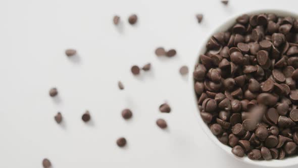 Video of overhead view of bowl of chocolate chip over white background alt