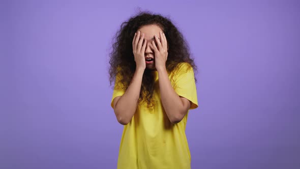 Frightened Woman Afraid of Something and Looks Into Camera with Big Eyes Full of Horror Over Violet alt