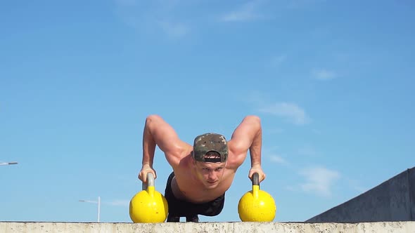 A Fit Young Man Doing Push-ups with Dumbbells. Slow Motion