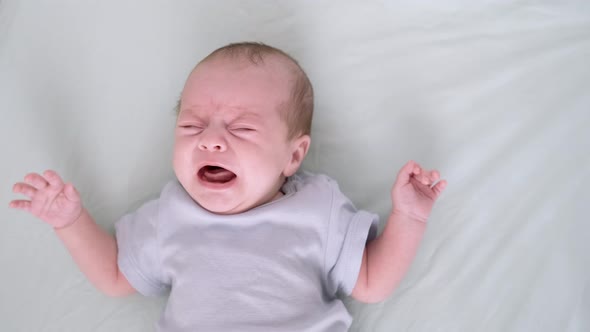 Dissatisfied Crying Upset Sad Newborn Baby Boy Lying in Nursery in Crib ...