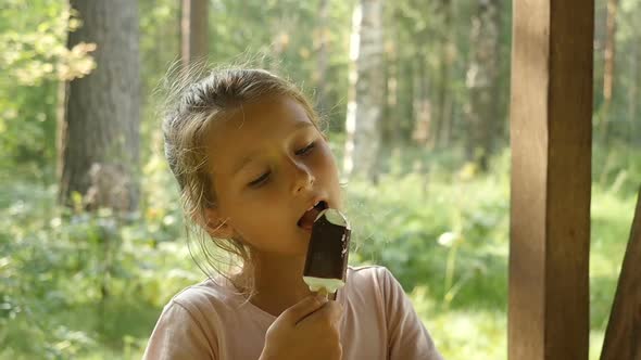 Little girl licking ice-cream. Charming Child Eats Ice Cream Outside.