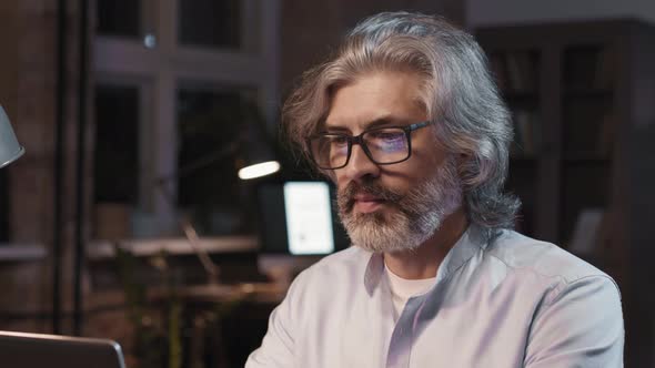 Portrait Of Smiling Man Working On Computer At Night alt