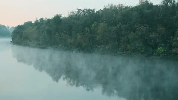 Smoke on the water. Fog floats over the river in the early morning at dawn. A beautiful lake