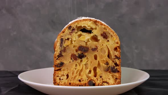 Powdered sugar poured onto Christmas Stollen fruit cake on dark background Festive pastry baking 4K alt