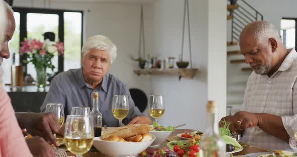 Portrait of happy senior diverse people having dinner at retirement home alt
