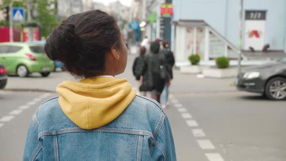 Back View of Stylish African American Woman in a Jean Jacket Walking City in the Downtown alt