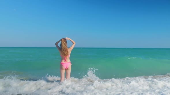 Tall Woman with a Long Hair From a Back is on a Beach alt