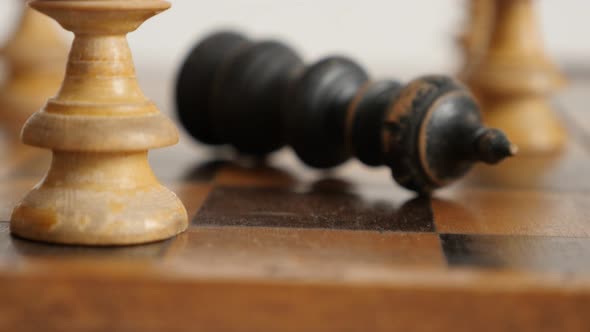 Shallow DOF of wooden chess set end game 4K 2160p 30fps UltraHD  footage - Knocking down black playe alt