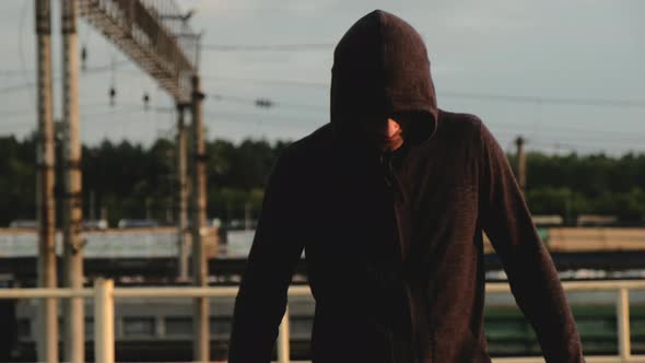 Portrait of male athlete on roof in evening at sunset during training. alt