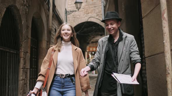 Beautiful and Style Friends Walking with Map and Camera Through Tight Street alt