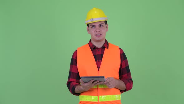 Happy Young Multi Ethnic Man Construction Worker Talking While Using Digital Tablet alt