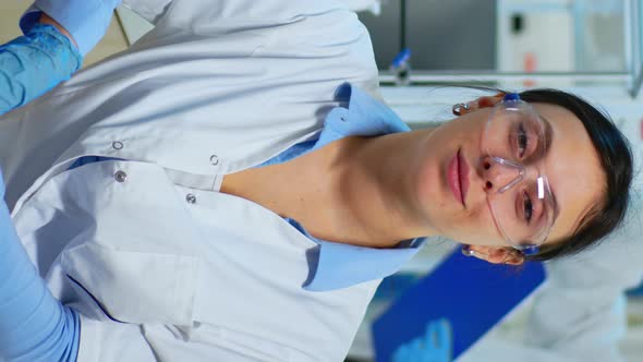 Vertical Video Portrait of Scientist Smiling at Camera Sitting in Modern Laboratory alt