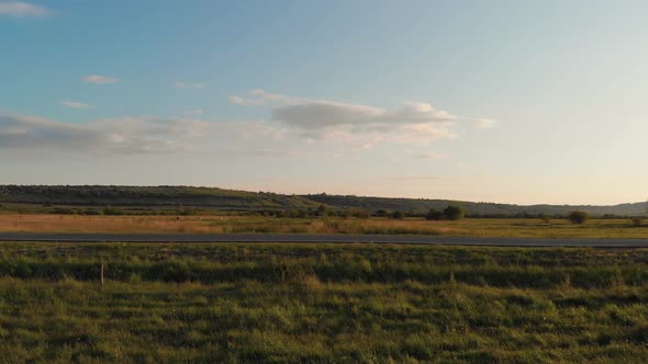 Aerial shot: flying along road with driving cars. alt
