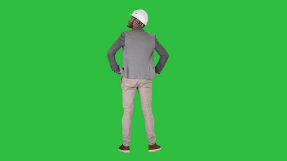 Engineer standing and looking around on a Green Screen, Chroma Key alt