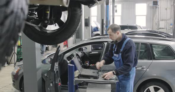 Mechanic Man Completed Examining A Car. Job Is Done alt