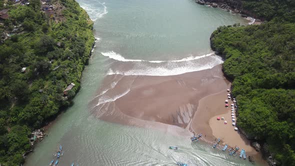 Aerial view of Baron beach in Yogyakarta, Indonesia with lighthouse and traditional boats alt