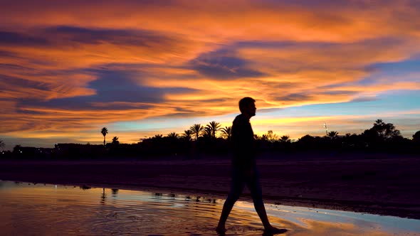 Person passing from right to left over the water watching the amazing sunset on a beautiful tropical alt