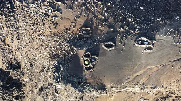 Close top-down drone footage of tent in rocks circle on the summit of the Piton des Neiges at the Re alt