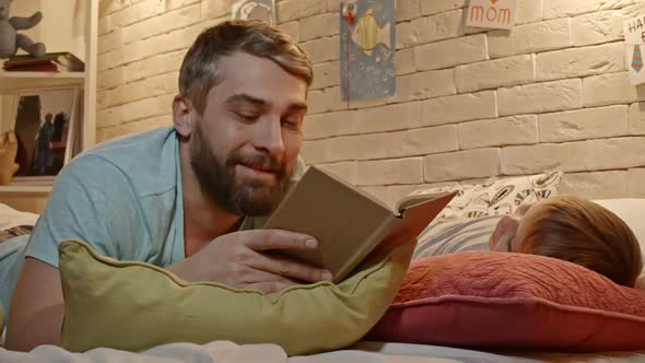 Dad Reading to Little Son in Bed alt