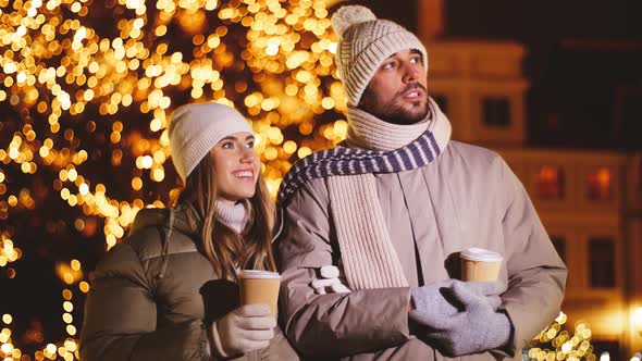 Couple with Coffee Talking in City on Christmas