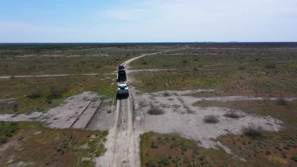 An Expedition of 3 Cars is Driving Through the Steppe Desert
