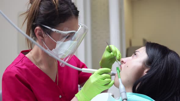 Woman at the Dental Hygienist Getting Professional Tooth Whitening and Ultrasound Cleaning alt