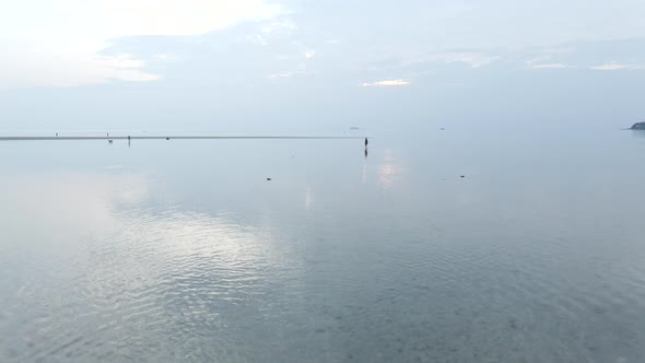 Interracial Couple Walking in Shallow Sea Water at Sunset  Aerial Flight Back alt