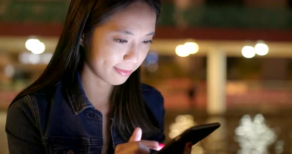 Woman use of mobile phone on earphone at night alt