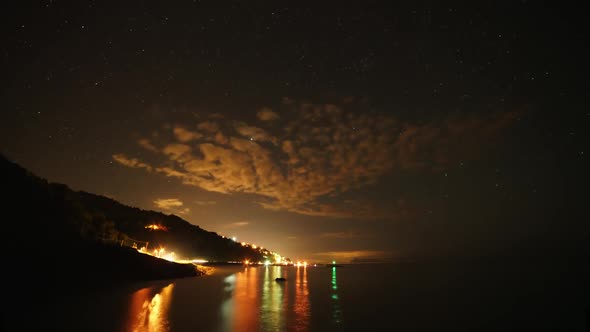 8K Stars in Night Sky and Harbor Lights by Sea