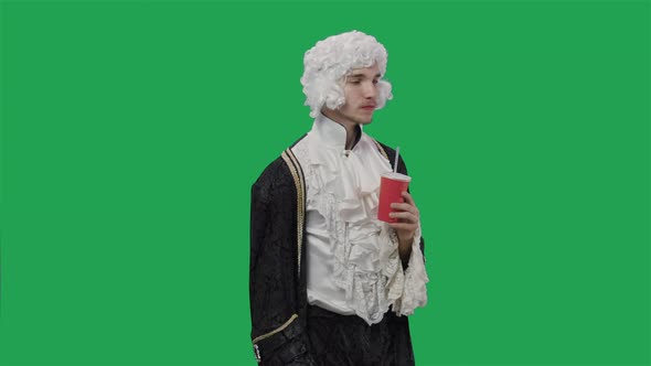 Portrait of Courtier Gentleman in Vintage Suit and Wig Drinking Drink From Plastic Glass Through alt