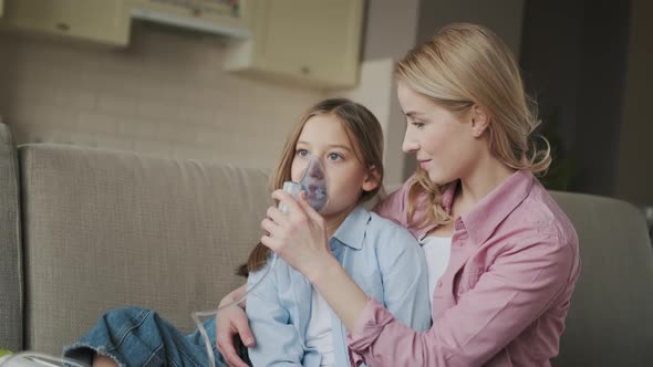 Mother is Helping Her Little Daughter with Breathing with Help of Nebulizer Which is Treating alt