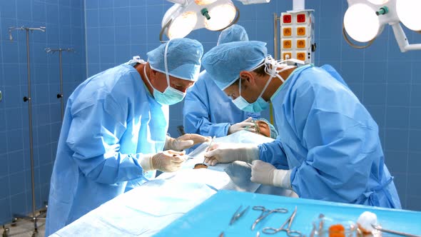 Surgeons performing operation in operation room alt