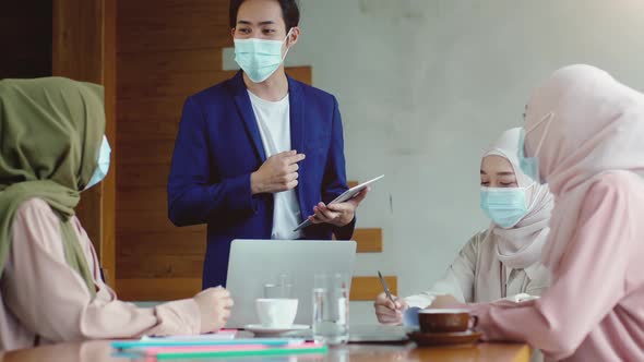 Upwardly mobile Asian Muslim business entrepreneur SME start up group of young man and women, discus alt