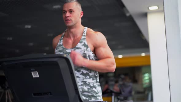 Muscular Athletic Bodybuilder Fitness Model Running Treadmill Gym Near Big Window alt