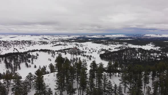 Wilderness Firetower on top of a mountain in the snow Aerial alt